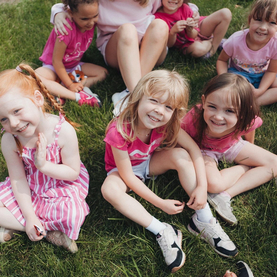 Group of girls sitting on grass smiling
