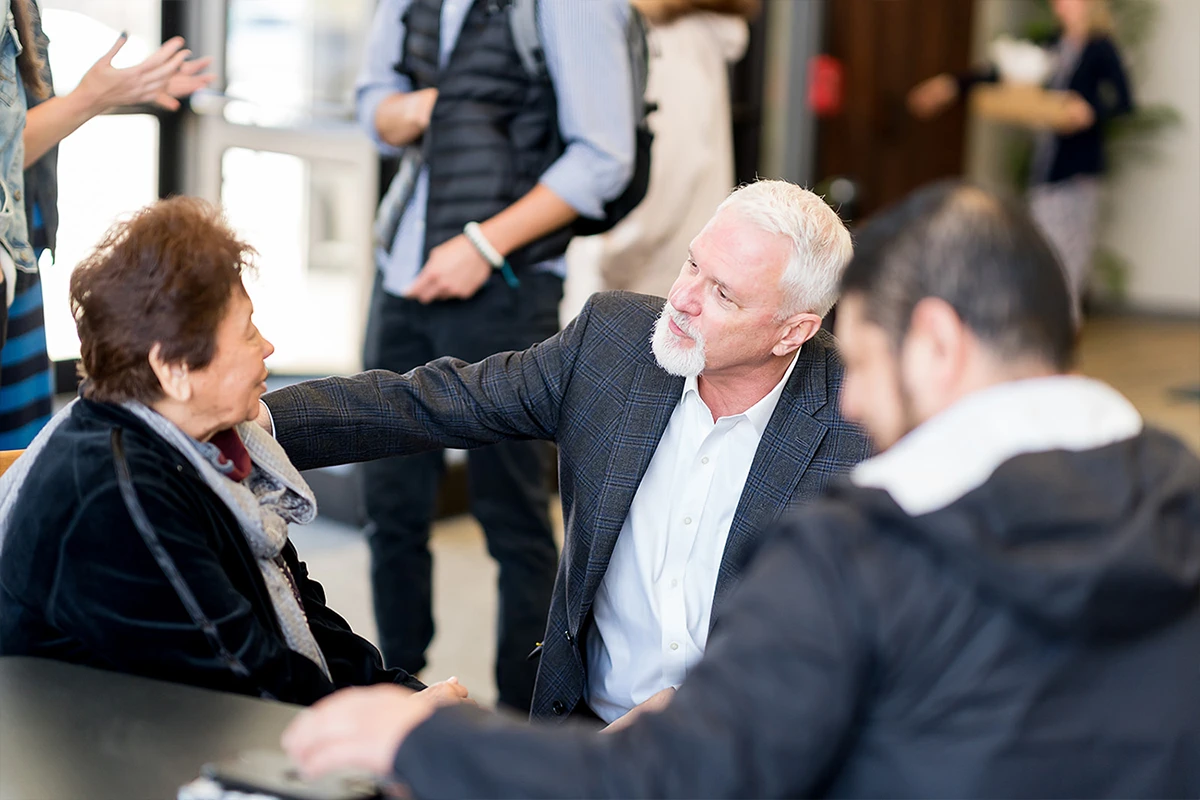 Women helping children at a registration table.