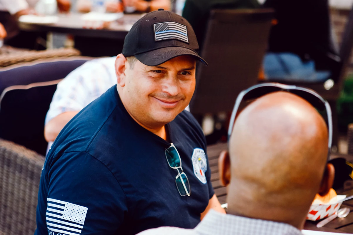 Gentlemen looking away talking with a firefighter.